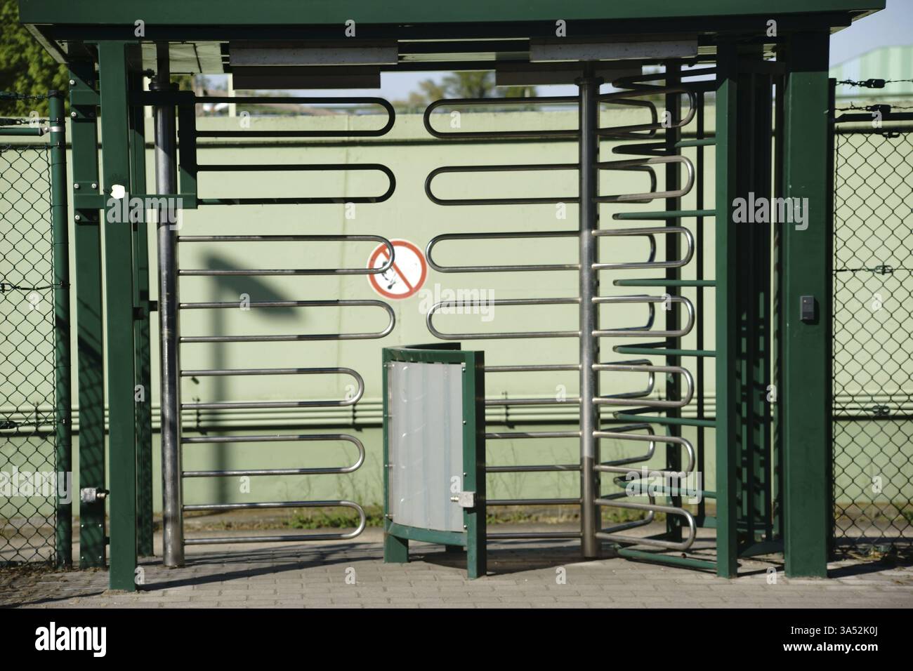 Ein drehbarer Eingang aus U-förmigen gebogenen Metallrohren zu einem Industriebereich Stockfoto