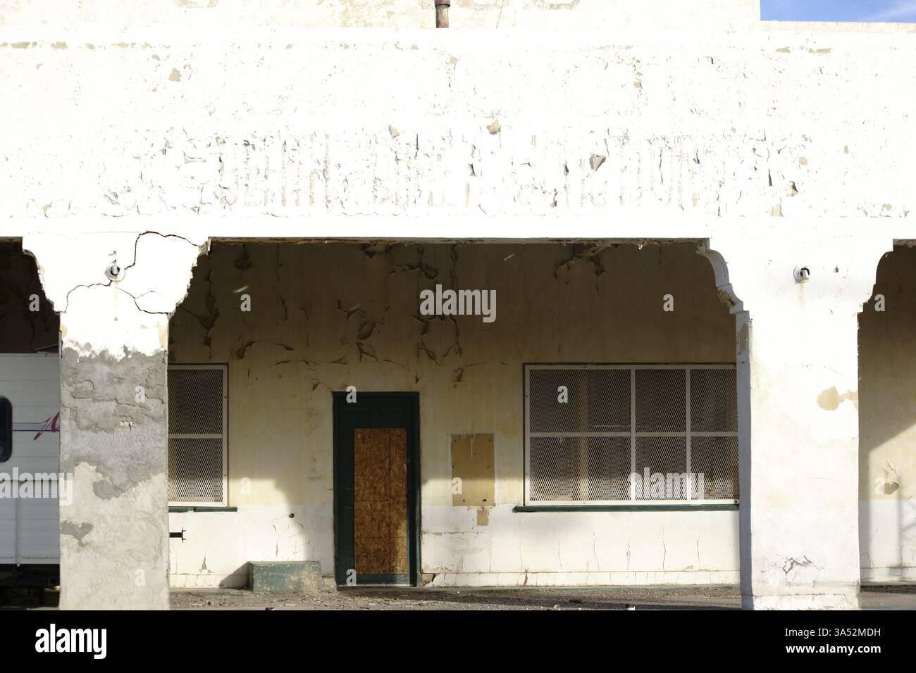 Ein heruntergekommenes Wohn- und Geschäftshaus mit einer vergilbten Fassade und abblätternden Gipsschichten Stockfoto