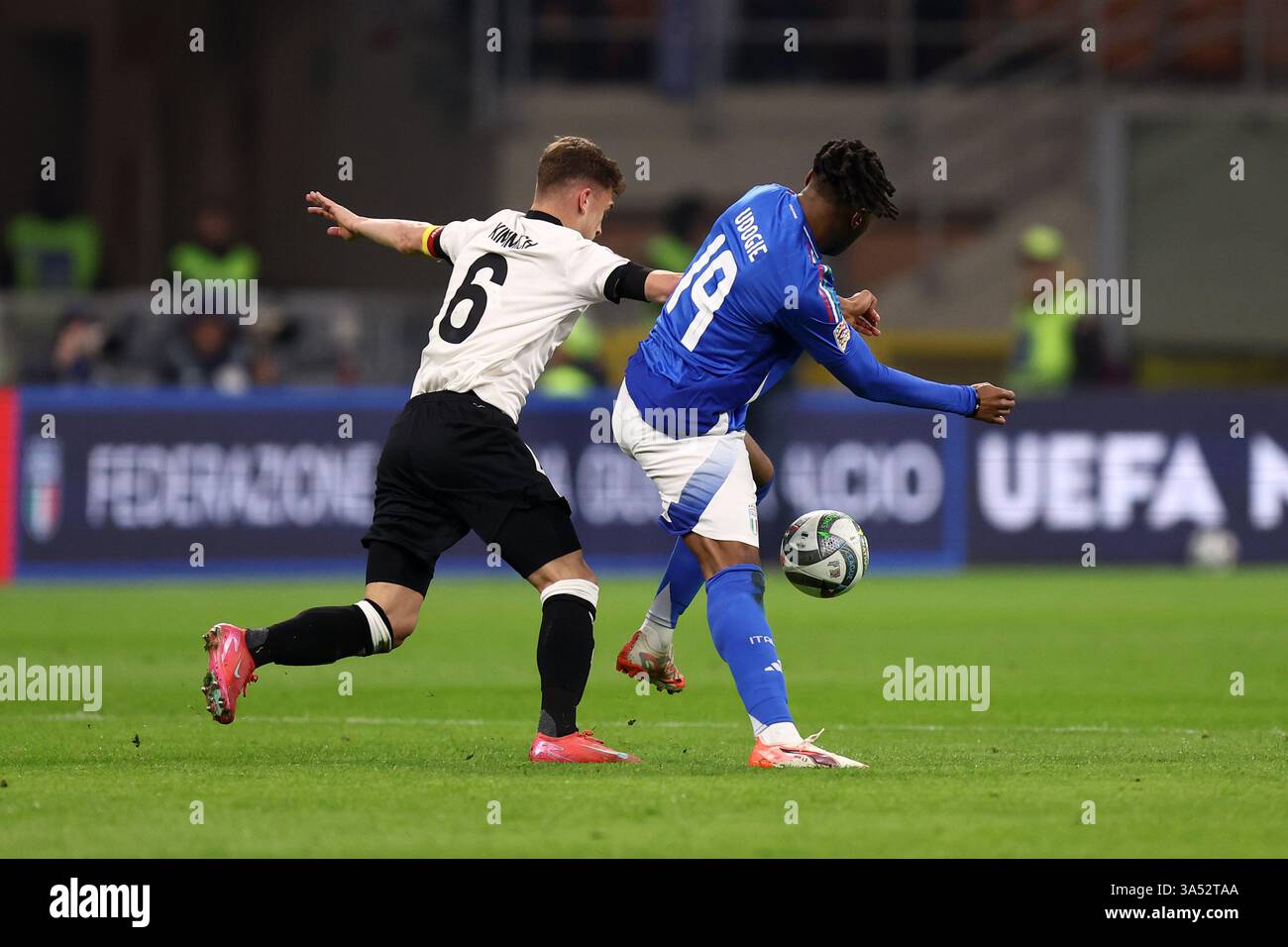 Mailand, Italien. März 2025. Joshua Kimmich (Deutschland) und Destiny Udogie (Italien) kämpfen um den Ball während des Viertelfinales der UEFA Nations League im Stadio San Siro am 20. März 2025 in Mailand. Quelle: Marco Canoniero/Alamy Live News Stockfoto