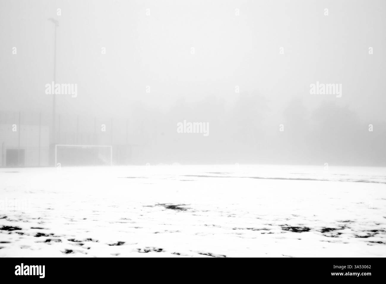 Die unspielbare Grasfläche eines Fußballplatzes unter einer Schneedecke im Nebel Stockfoto Die unspielbare Grasfläche eines Fußballplatzes unter einer Schneedecke im Nebel Stockfoto