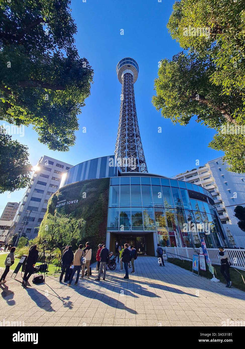 Yokohama Marine Tower in der Präfektur Kanagawa, Japan mit einer Gruppe von Personen darunter. Stockfoto
