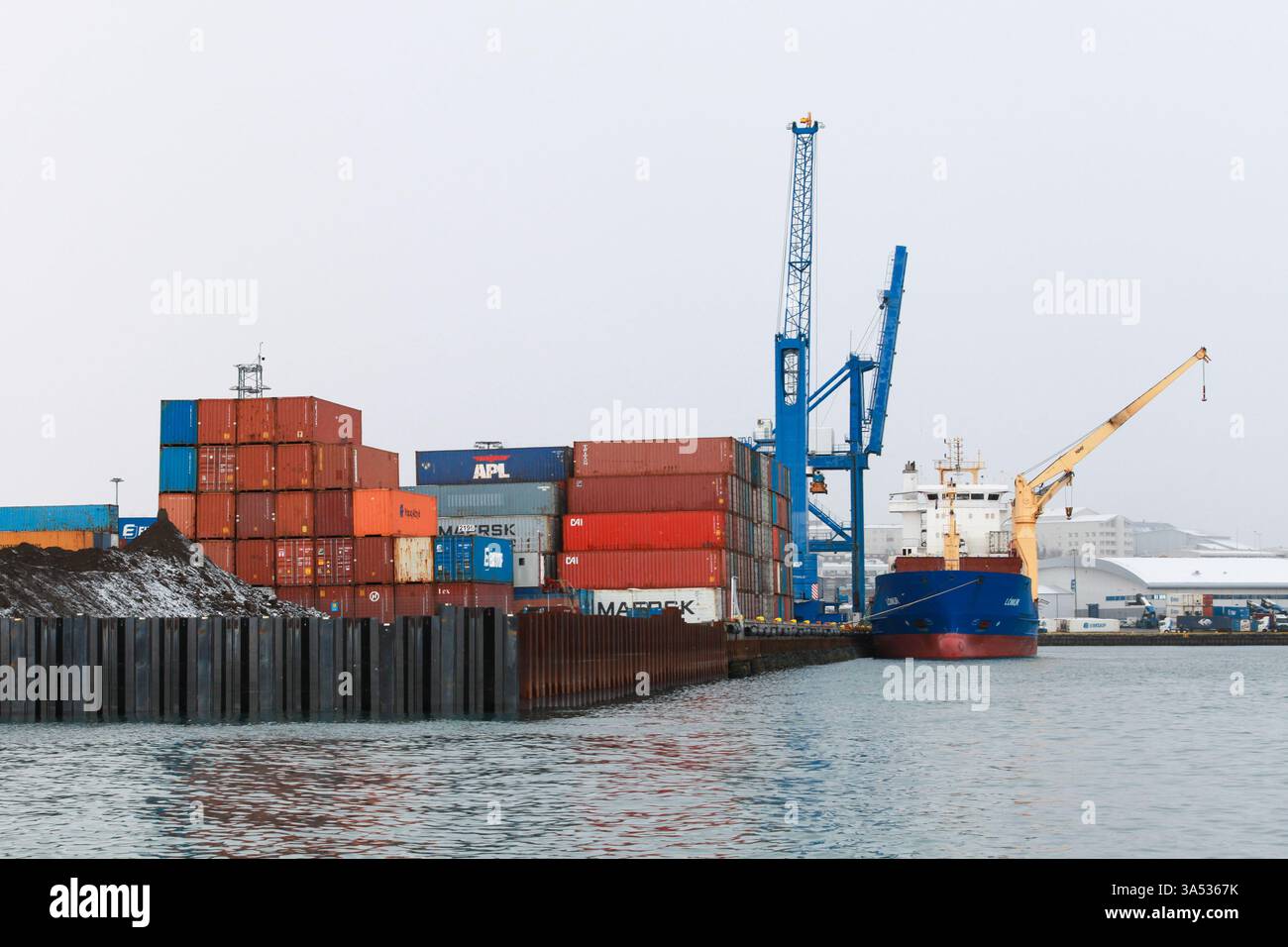 Reykjavik, Island – 4. April 2017: Container und Kräne in einem maritimen Industrieknotenpunkt, der die globale Handelslogistik repräsentiert Stockfoto