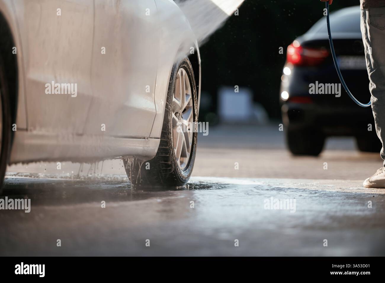 Konzeption der Autowaschanlage. Der Mann ist mit seinem Auto draußen. Stockfoto