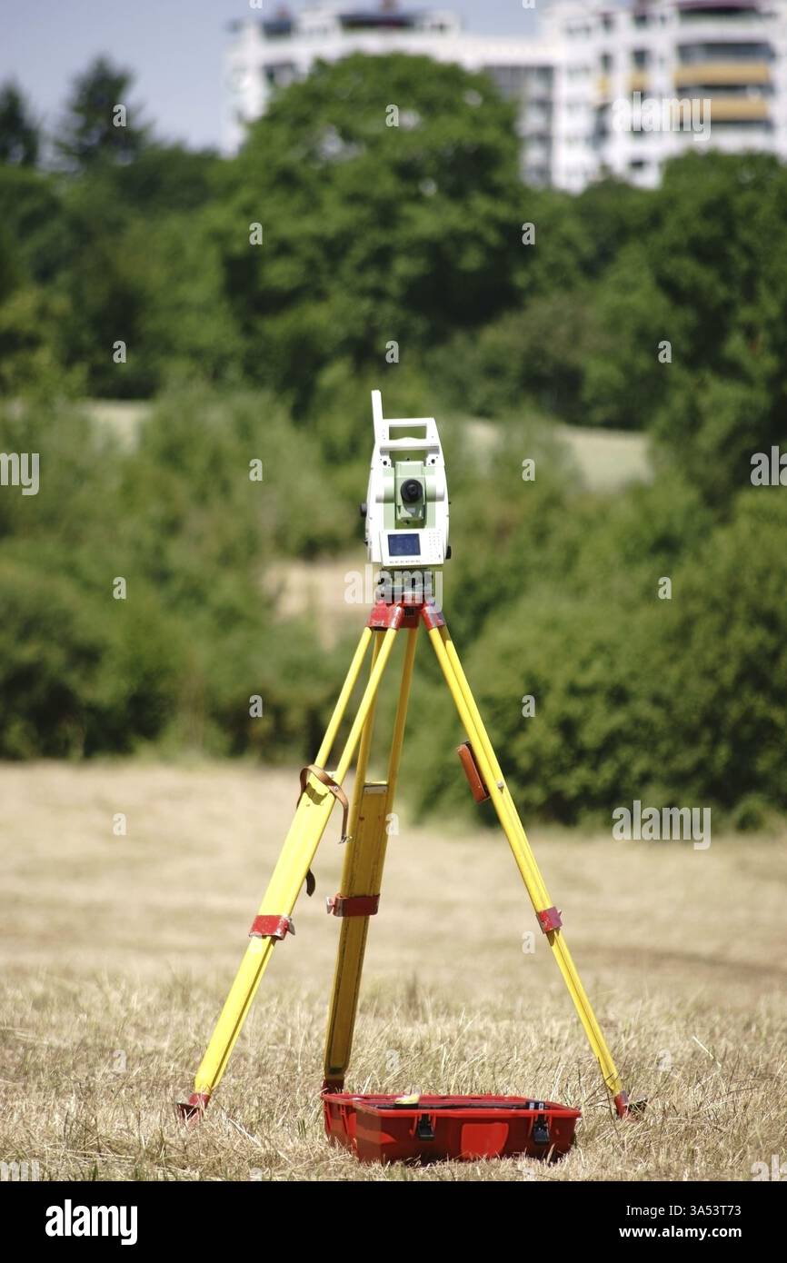 Ein Nivelliergerät auf einem dreiarmigen Stativ für die Landschaftsvermessung Stockfoto