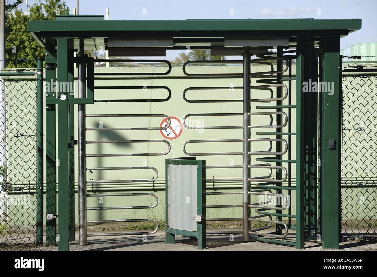 Ein drehbarer Eingang aus U-förmigen gebogenen Metallrohren zu einem Industriebereich Stockfoto