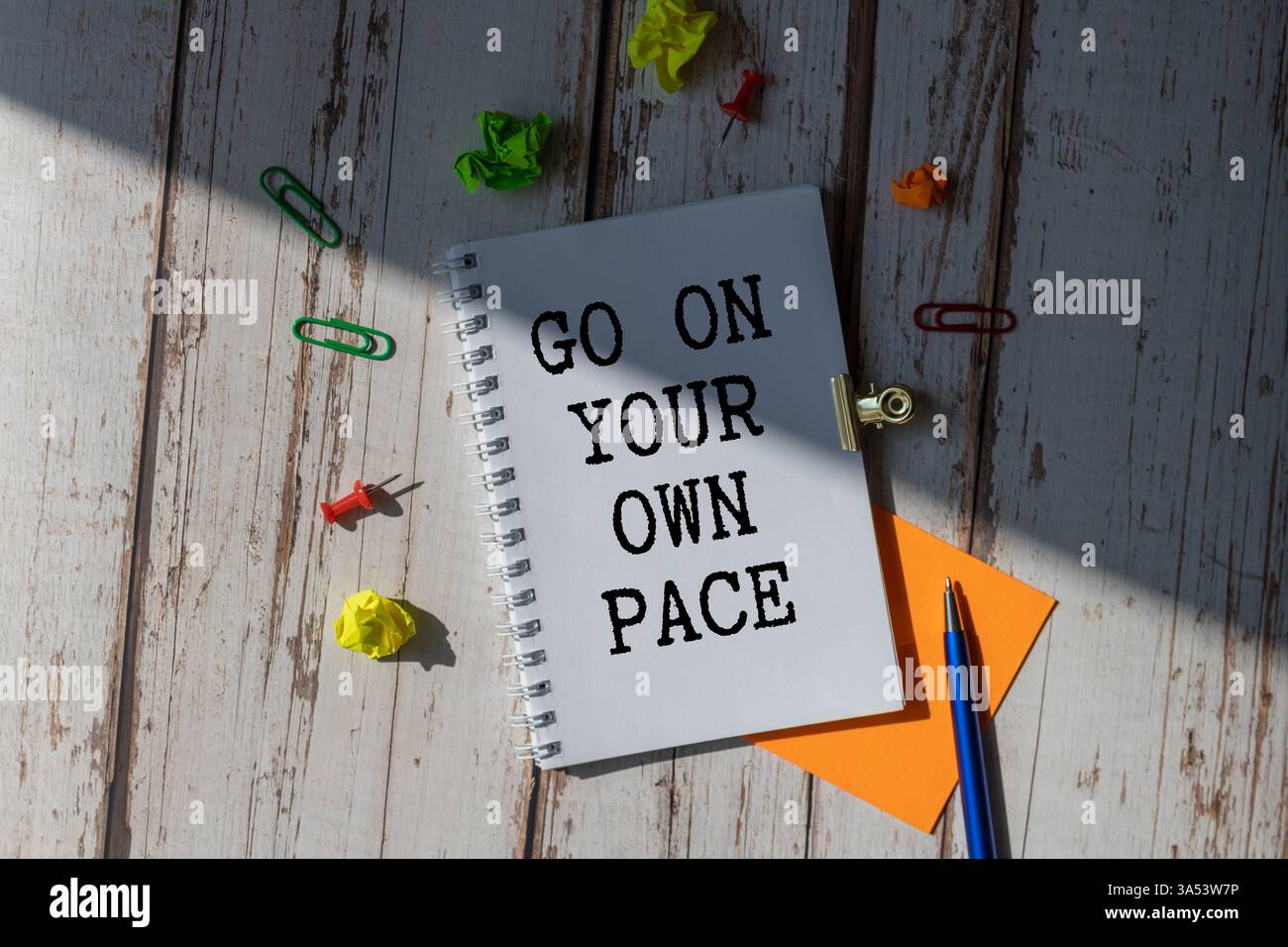 Retro-Effekt und getöntes Bild einer Frau, die eine Notiz mit einem Füllfederhalter auf ein Notizbuch schreibt. Handgeschriebener Text Gehen Sie in Ihrem eigenen Tempo als Erfolg und evo Stockfoto