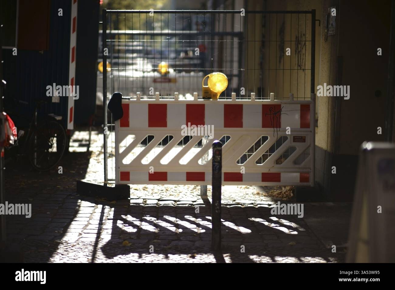 Eine Straßensperre mit gelben Signalleuchten auf einer Baustelle gegen das Licht Stockfoto