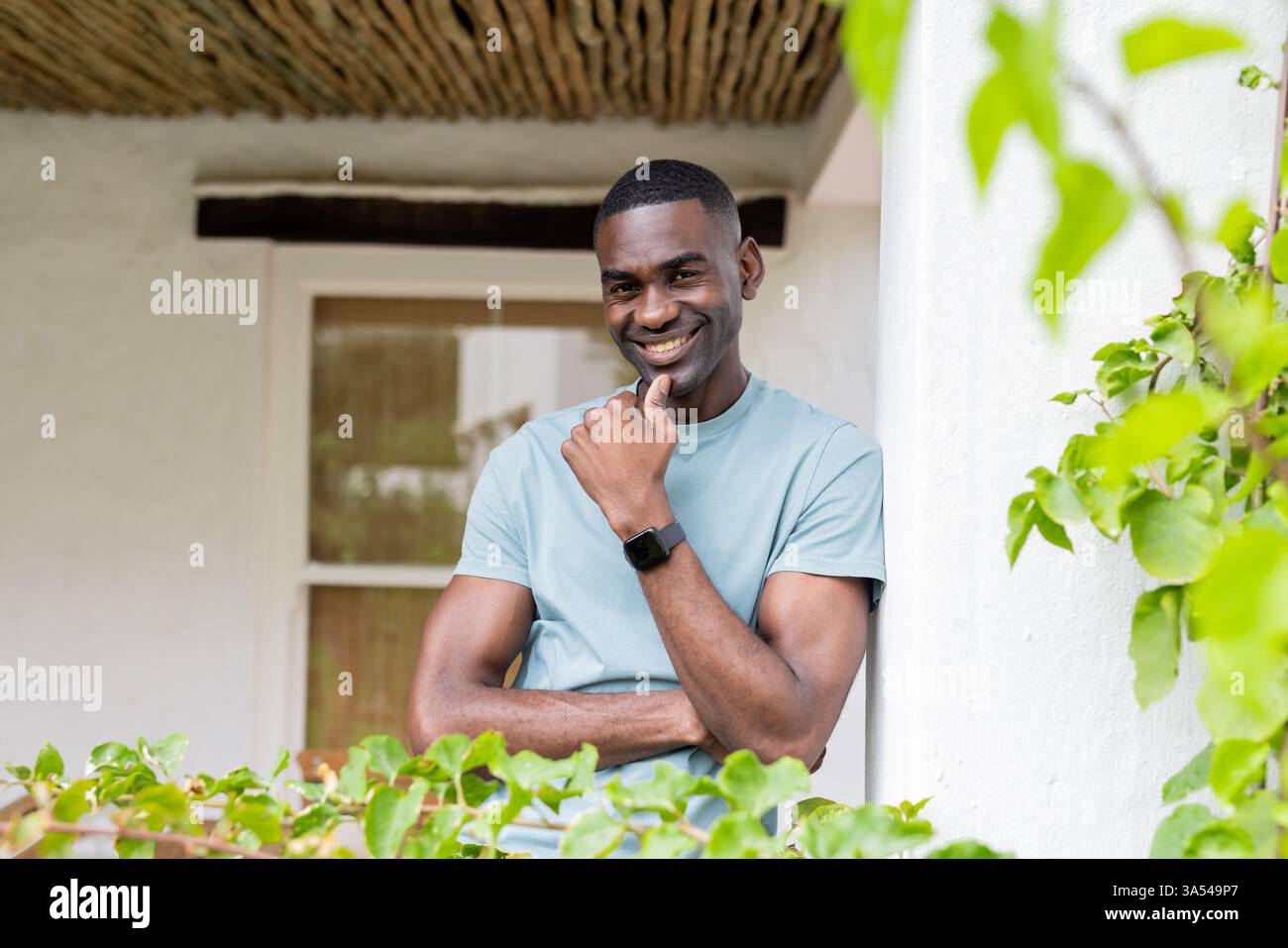 Lächelnder Mann in Freizeitkleidung, der entspannende Momente im Urlaub im Freien genießt Stockfoto