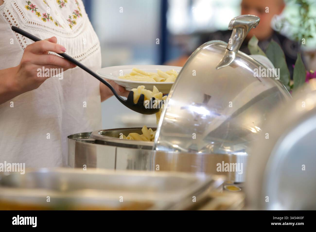 Eine Frau, die Essen von einem Buffet nimmt Stockfoto
