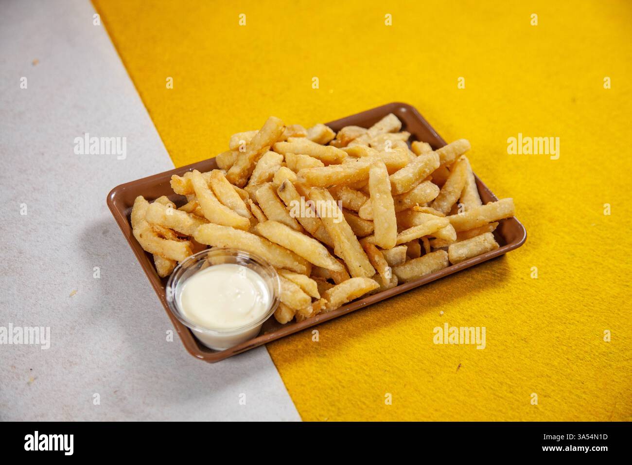 Knoblauch Mayo Street Food Cart Kartoffelchips Pommes auf gelbem und weißem Hintergrund. Stockfoto
