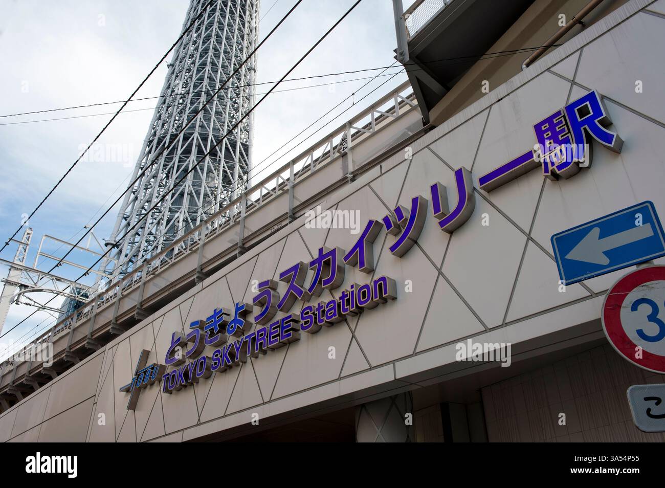 Schildern Sie an der Gebäudefassade der Tobu Line Tokyo Skytree Station mit der Basis des Skytree im Hintergrund, Sumida Ward, Tokio, Japan. Stockfoto