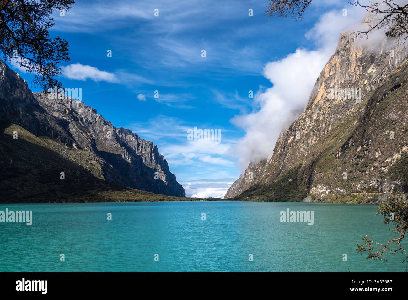 Ein atemberaubender türkisfarbener See reflektiert den blauen Himmel, eingebettet zwischen hoch aufragenden Bergen. Die friedliche Landschaft ist Teil der berühmten Laguna 69 Trek in Hu Stockfoto
