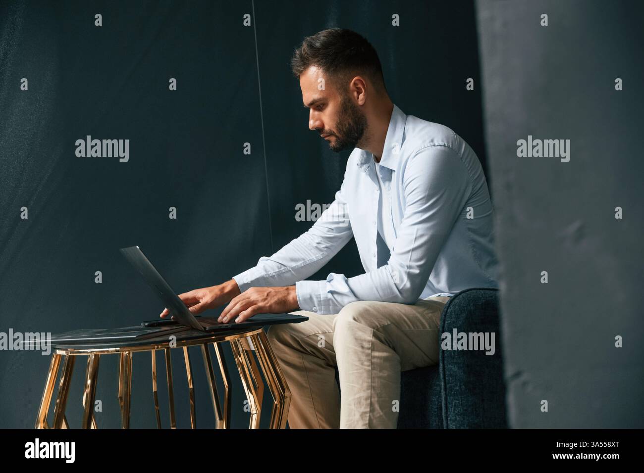Fokussiert, selbstbewusst. Geschäftsmann sitzt und arbeitet mit Laptop. Stockfoto
