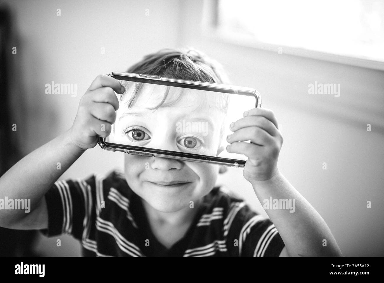 Dummes Kleinkind, das mit dem Telefon spielt Stockfoto Dummes Kleinkind, das mit dem Telefon spielt Stockfoto