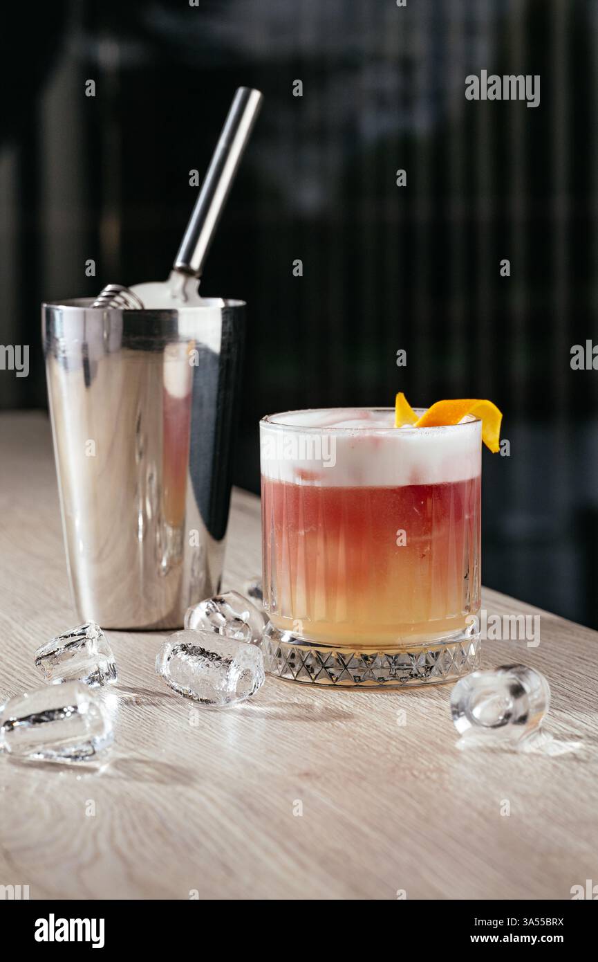 Saurer Cocktail mit Eis und Orangenschale Stockfoto