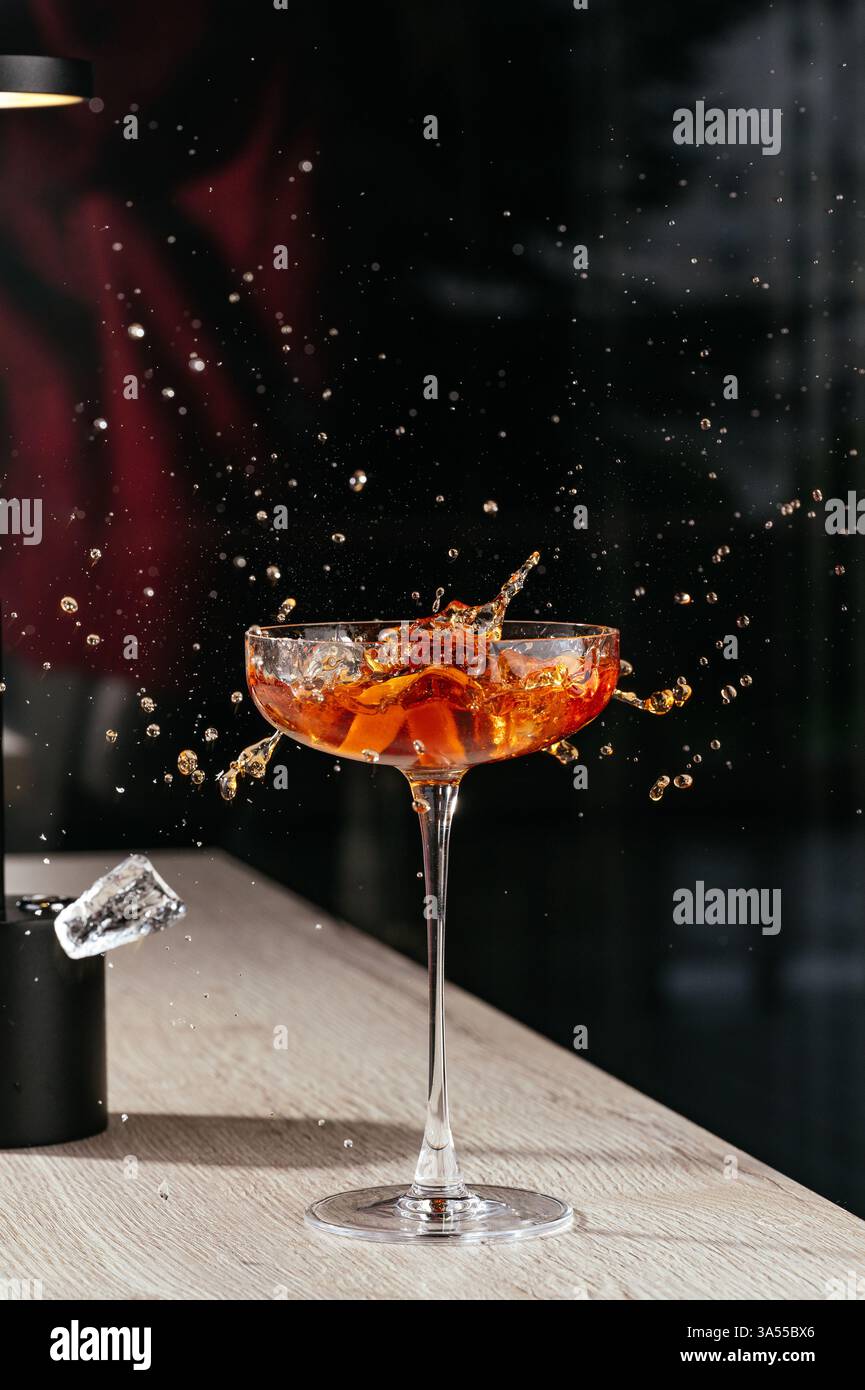 Manhattan Cocktail mit Spritzern und Eiswürfel Stockfoto