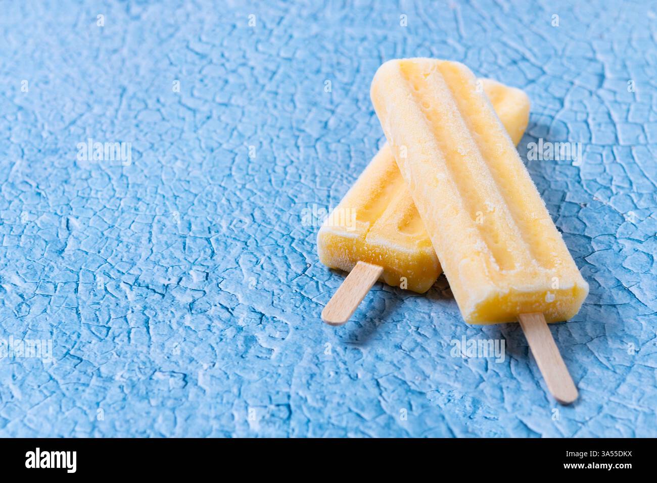Gelbes Eis auf blauem Hintergrund Stockfoto