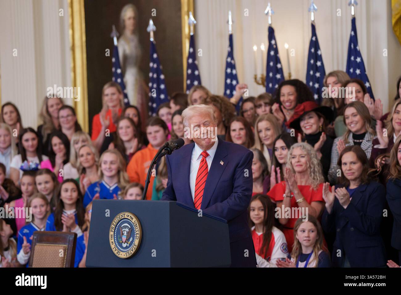 Präsident Donald Trump – umgeben von Frauen und Mädchen – hält eine Erklärung ab, als er am Mittwoch, den 5. Februar 2025, im östlichen Saal des Weißen Hauses eine „No Men in Women’s Sports“-Anordnung unterzeichnet. Stockfoto