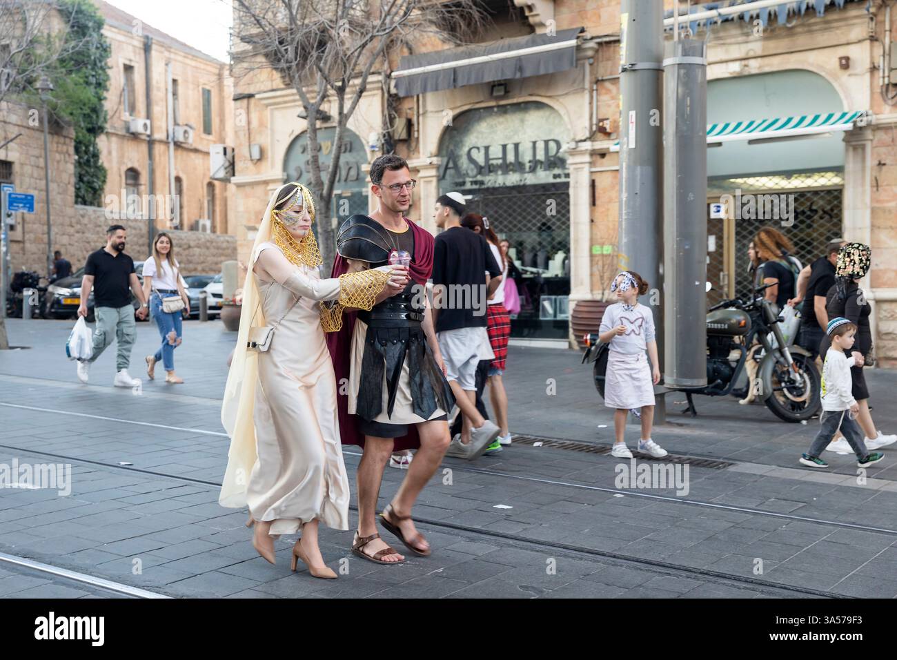 Jerusalem, Israel – 16. März 2025. Ein Mann und eine Frau in Ritterkostümen gehen die Straße entlang. Purim in der Stadt. Stockfoto