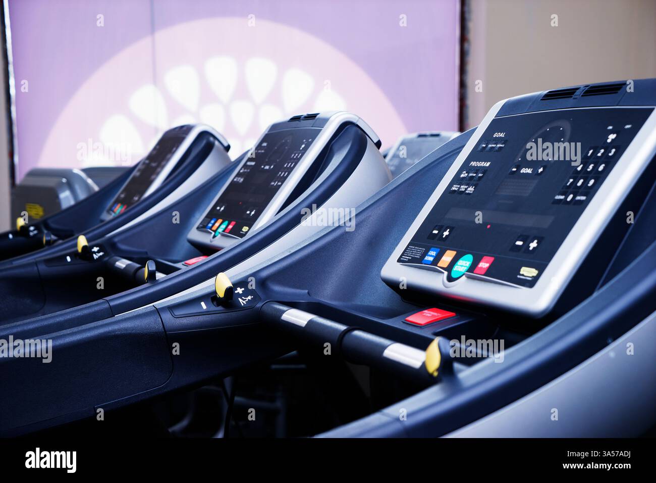 Moderne Innenausstattung des Fitnessstudios mit Geräten. Fitnessclub mit Laufbändern für Fitness-Cardio-Training bei abendlicher Beleuchtung. Gesundes Lifestyle-Konzept Stockfoto