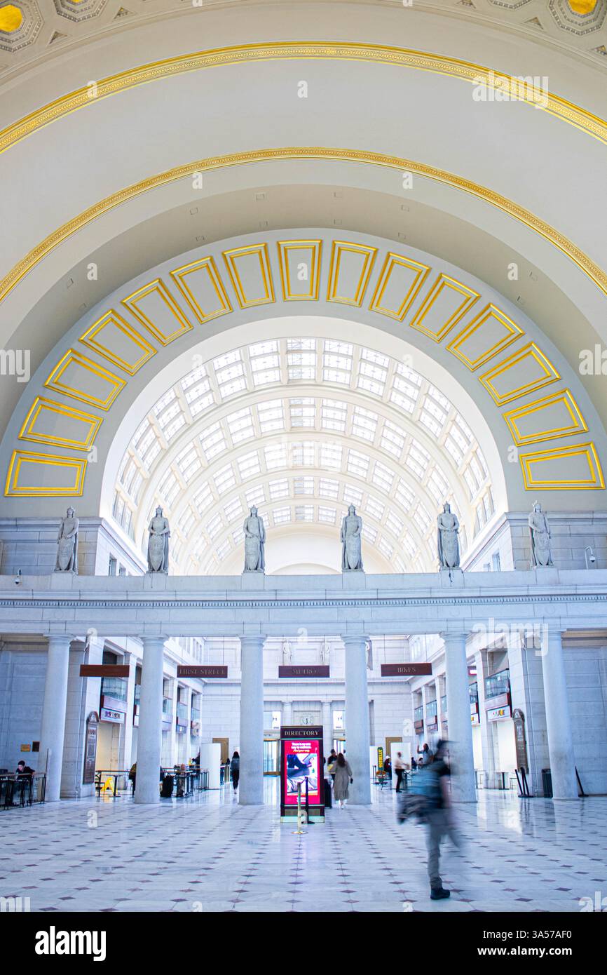 Goldene Details in einer eleganten Halle mit Skulpturen und Pendlern der Union Station. Stockfoto
