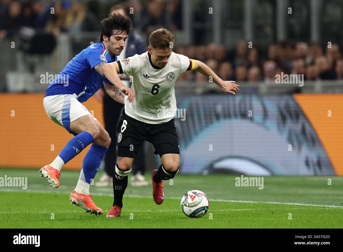 Mailand, Italien. März 2025. Sandro TONALi (Italien) und Joshua Kimmich (Deutschland) kämpfen um den Ball während des Viertelfinales der UEFA Nations League im Stadio San Siro am 20. März 2025 in Mailand. Quelle: Marco Canoniero/Alamy Live News Stockfoto