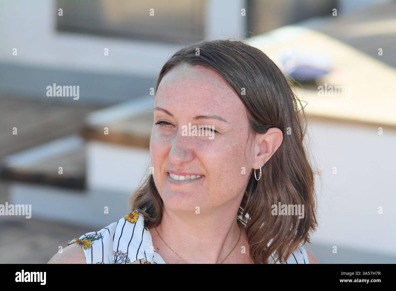 Das Porträt zeigt das warme und einladende Lächeln einer Frau und eignet sich so für Werbung, Blogs oder jeden Kontext, in dem ein freundliches Gesicht ist Stockfoto