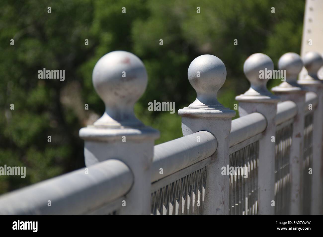 Eine Reihe von Kugelgelenken entlang der Spitze eines Stahlgeländers einer Brücke. Stockfoto