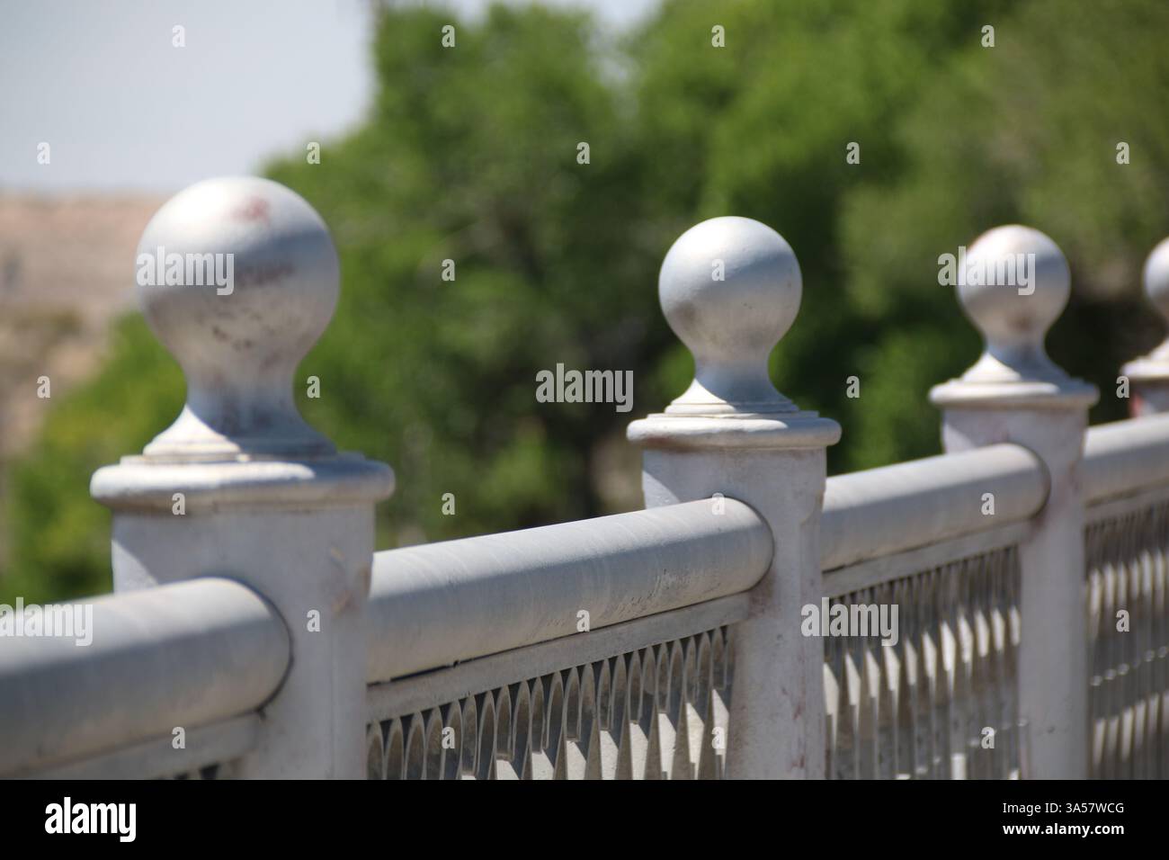 Eine Reihe von Kugelgelenken entlang der Spitze eines Stahlgeländers einer Brücke. Stockfoto