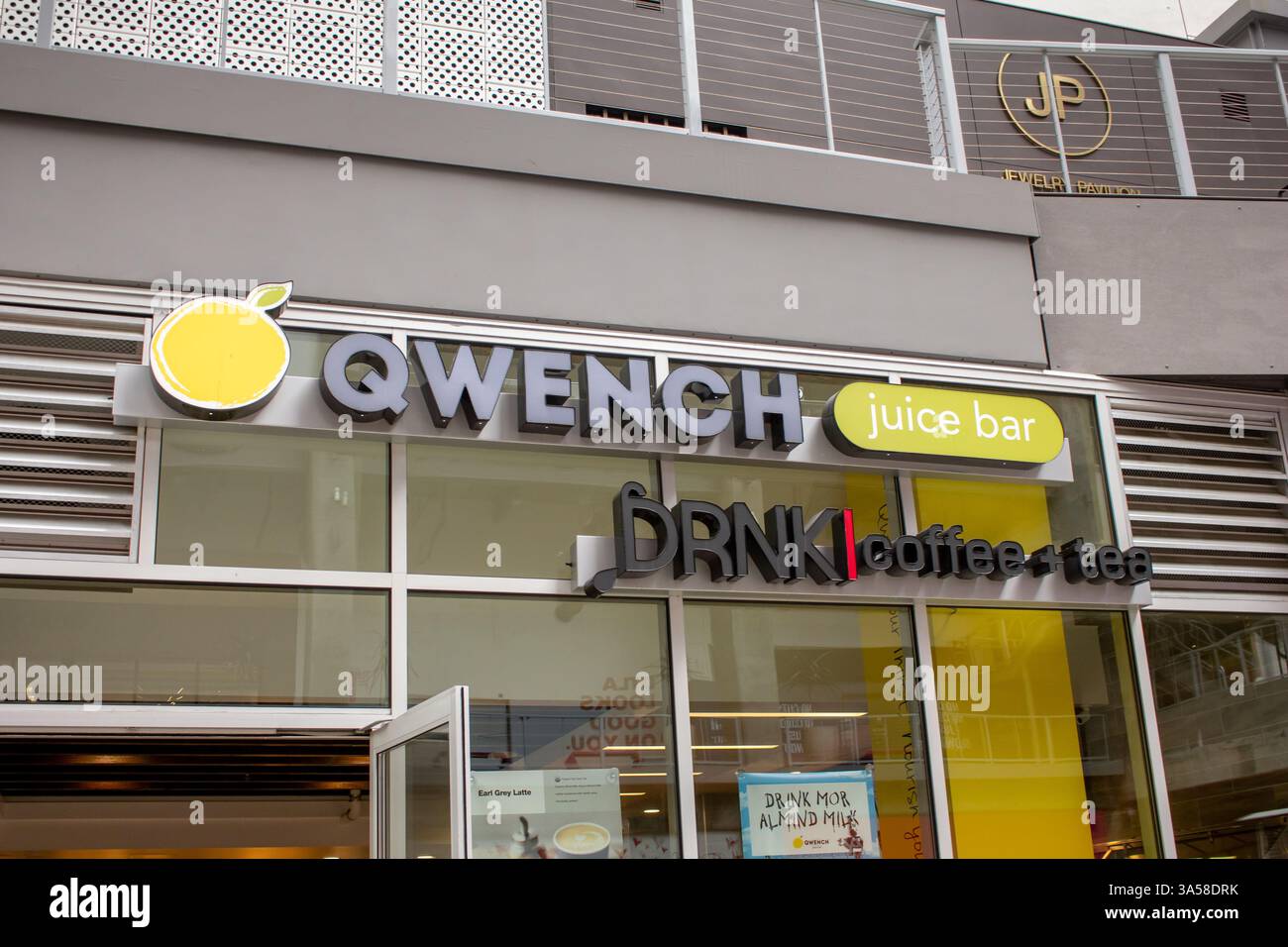 Los Angeles, Kalifornien, USA - 25.06.2019: Blick auf ein Ladenschild für Qwench Juice Bar und DRNK Coffee and Tea, im Block. Stockfoto