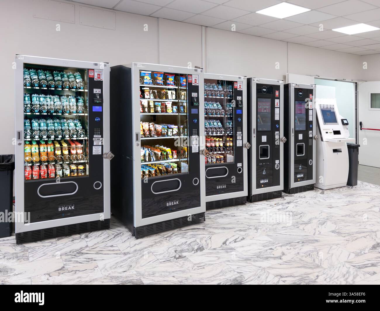 Italien - 20. März 2025: Automatische Spender für alkoholfreie Getränke, Wasser, Snacks und Kaffee im Pausenbereich Stockfoto