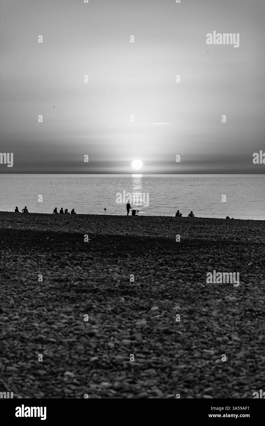 Ruhige Sonnenuntergangsszene am Strand von Batumi, der Schwarzmeerküste, Gerogia. Batumi zieht Besucher mit seinem subtropischen Klima und seinen Attraktionen an. Stockfoto