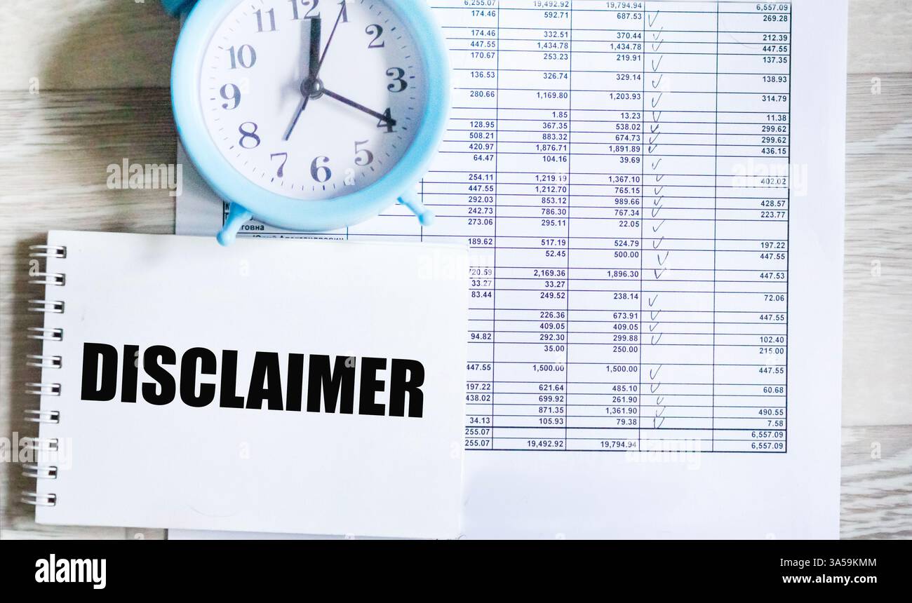 Ein Symbol des Haftungsausschlusses. Das Konzeptwort Disclaimer auf dem Notizblock. Der blaue Wecker steht auf dem Jahresabschluss. Stockfoto