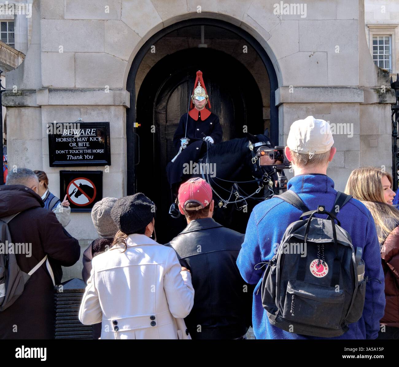 Touristen, die einen Soldaten zu Pferd bei der Horse Guards Parade in London sehen Stockfoto