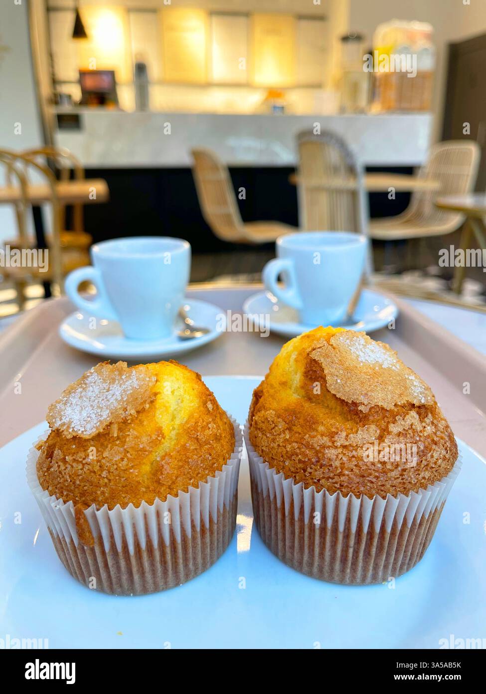 Zwei Muffins und zwei Tassen Kaffee in einer Cafeteria. - Smartphone-aufgenommenes Stockfoto