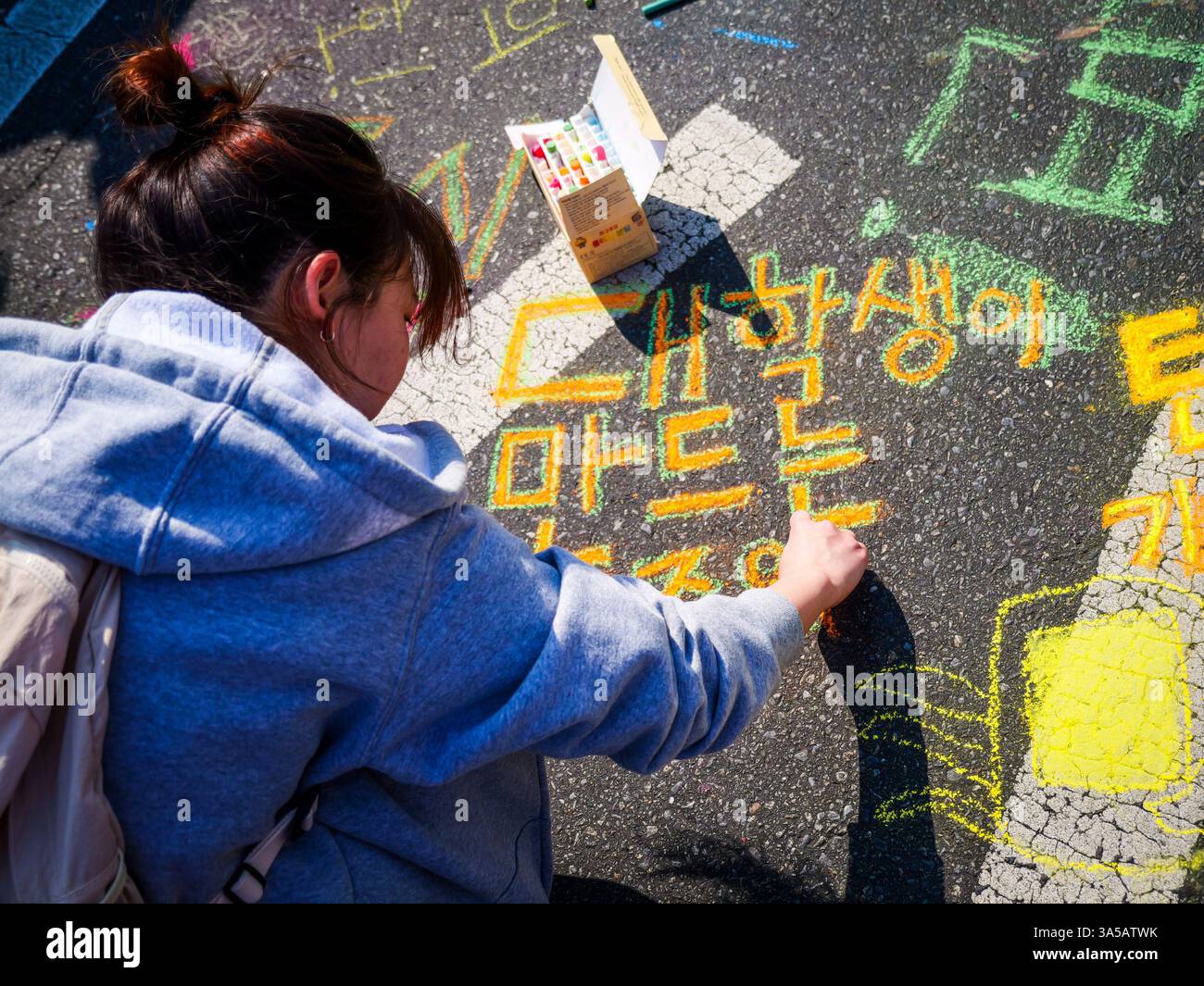 Seoul, Südkorea. März 2025. Ein Demonstrant schreibt in Bürgersteig-Kreide und ruft dazu auf, den angeklagten südkoreanischen Präsidenten Yoon Suk Yeol bei einer massiven Kundgebung in der Nähe des Gyeongbokgung Palace in der Innenstadt von Seoul, Südkorea, am Samstag, den 22. März 2025, aus seinem Amt zu entfernen. Das Land wartet gespannt auf ein Urteil des Verfassungsgerichts darüber, ob Yoons Amtsenthebung aufrechterhalten werden soll. Foto: Thomas Maresca/UPI Credit: UPI/Alamy Live News Stockfoto Seoul, Südkorea. März 2025. Ein Demonstrant schreibt in Bürgersteig-Kreide und ruft dazu auf, den angeklagten südkoreanischen Präsidenten Yoon Suk Yeol bei einer massiven Kundgebung in der Nähe des Gyeongbokgung Palace in der Innenstadt von Seoul, Südkorea, am Samstag, den 22. März 2025, aus seinem Amt zu entfernen. Das Land wartet gespannt auf ein Urteil des Verfassungsgerichts darüber, ob Yoons Amtsenthebung aufrechterhalten werden soll. Foto: Thomas Maresca/UPI Credit: UPI/Alamy Live News Stockfoto