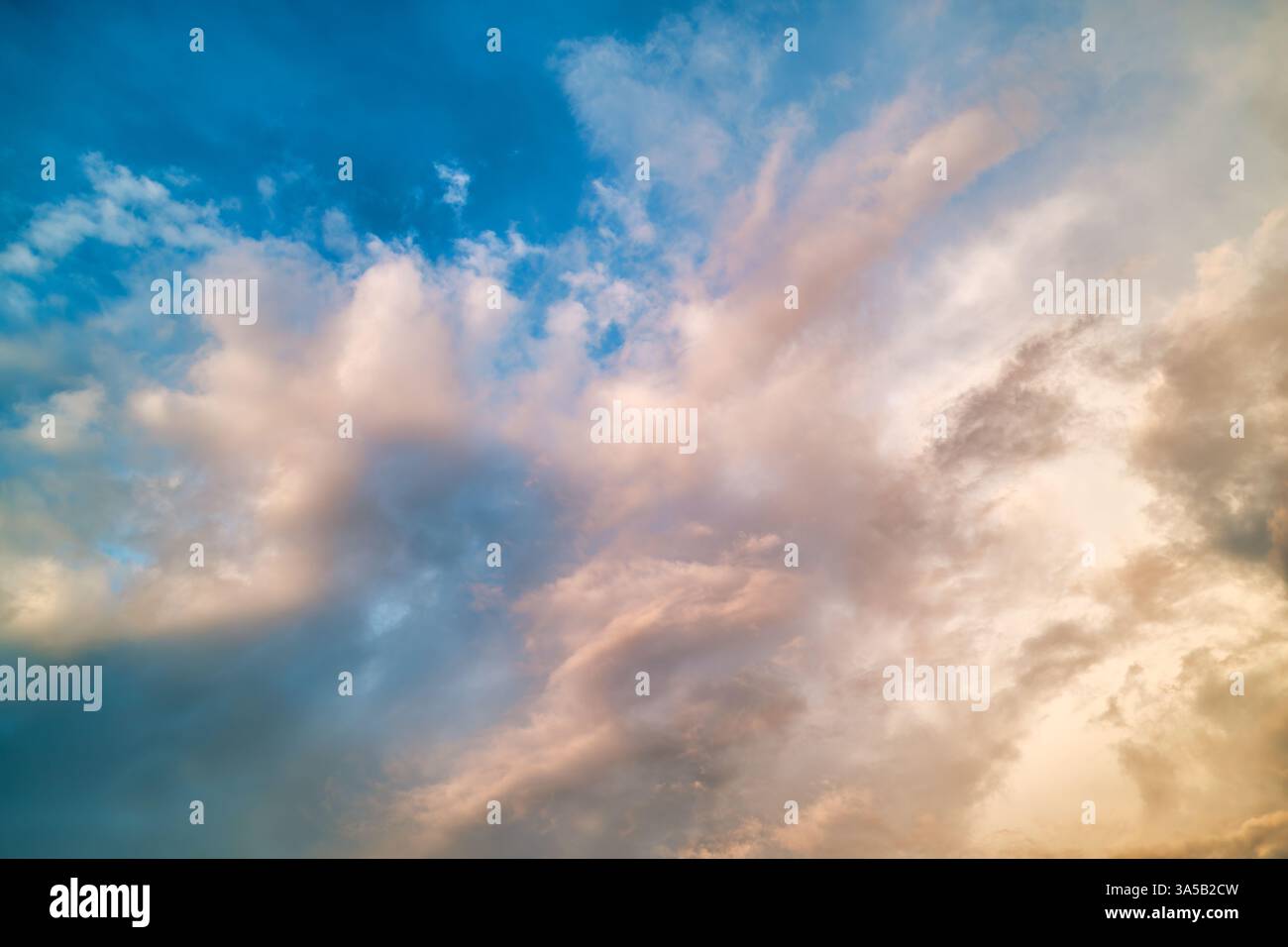 Halten Sie die Schönheit eines dynamischen Himmels mit weichen Wolken und einer leuchtend blauen Palette bei Sonnenuntergang fest. Die Szene weckt Gelassenheit und Staunen. Stockfoto