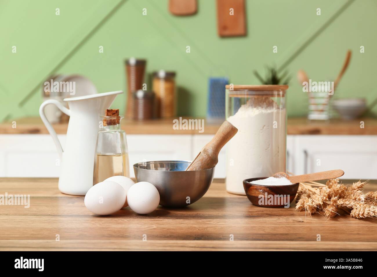 Frische Eier, Mehl, Backpulver und Öl auf Holztisch in der Küche Stockfoto