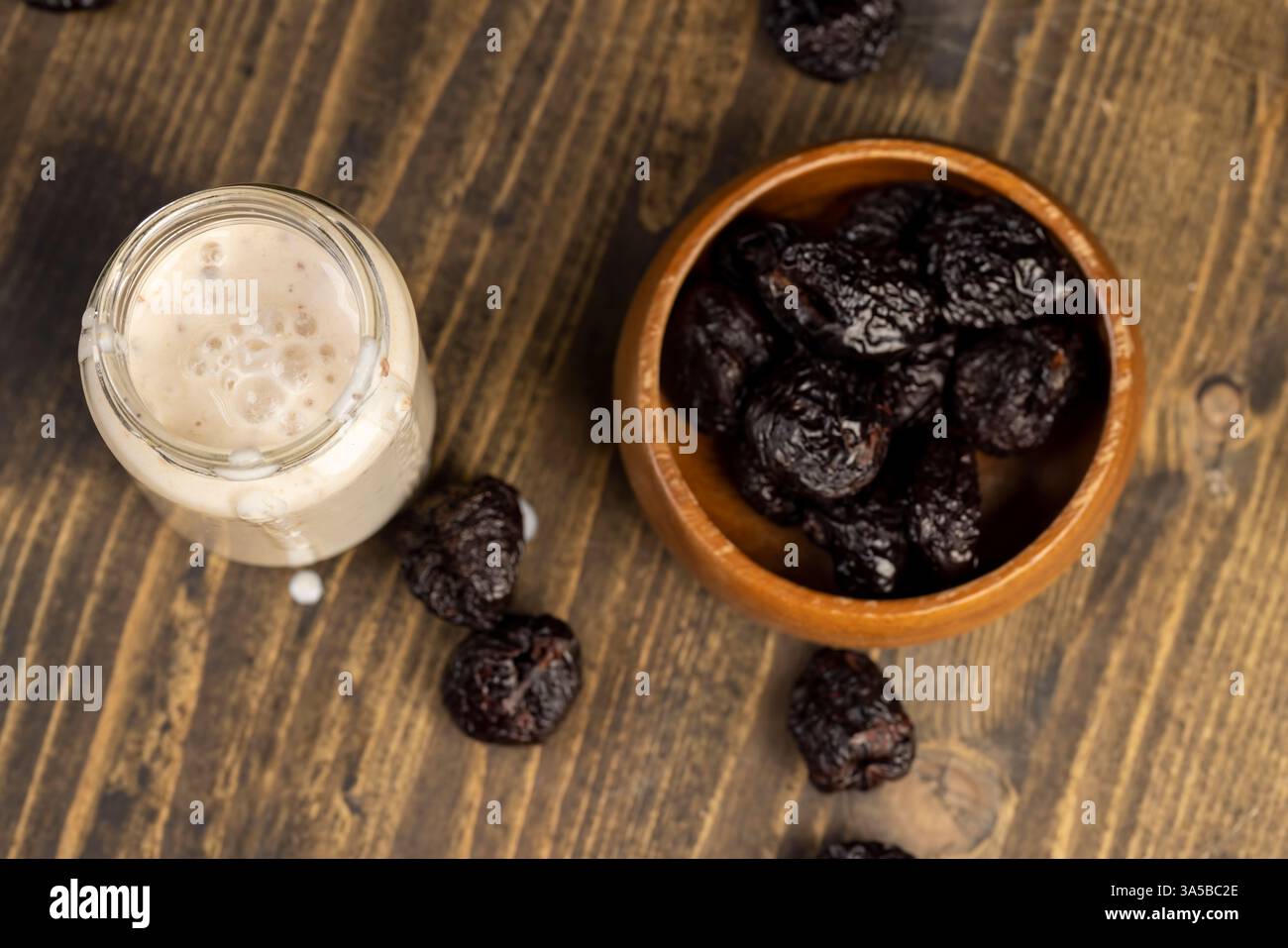 Frischer Joghurt mit Pflaumengeschmack mit getrockneten Pflaumenscheiben, Glas mit natürlichem Pflaumenjoghurt, Blick von oben Stockfoto