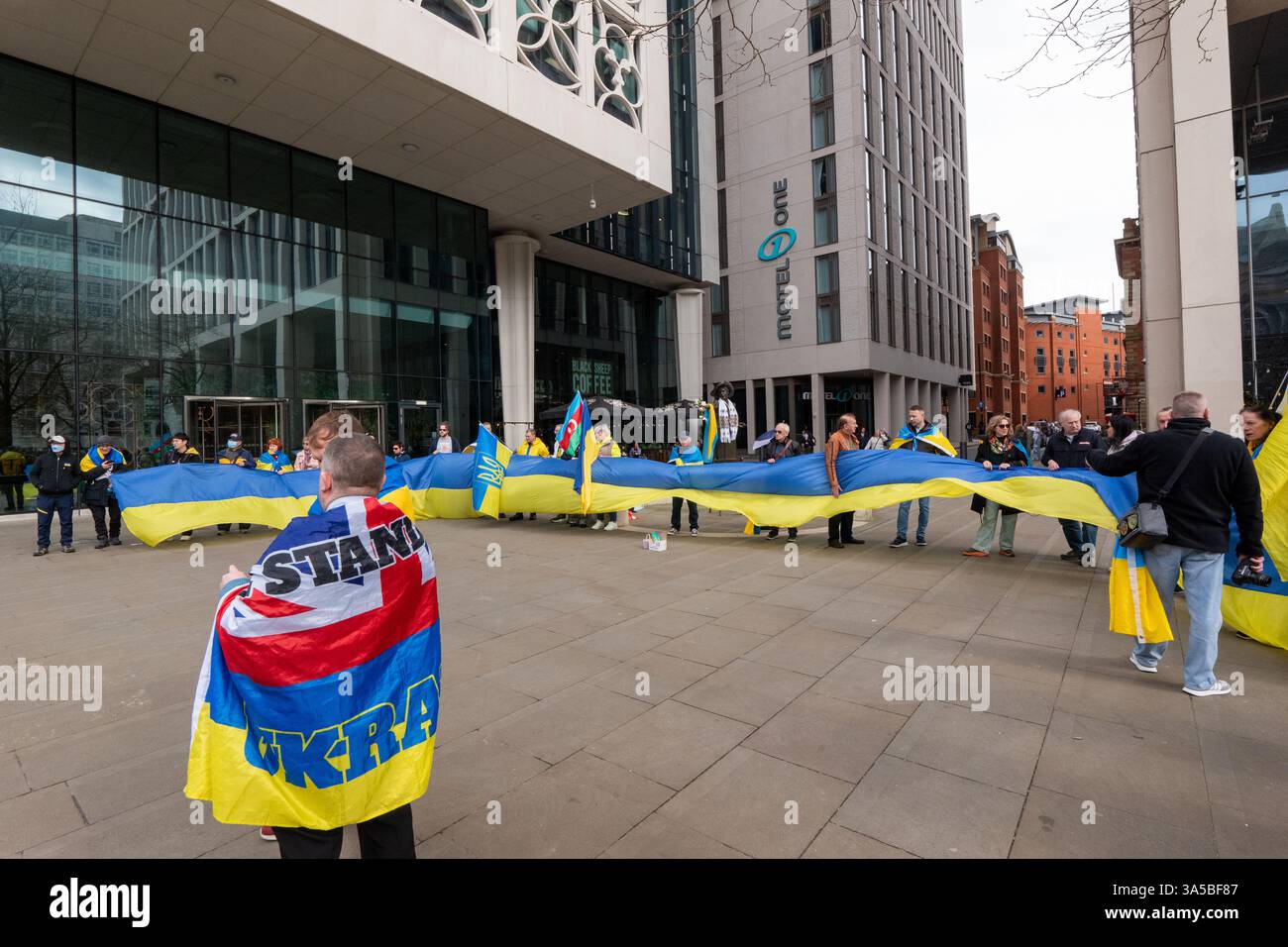 Eine Menschenmenge versammelte sich auf dem Petersplatz in Manchester mit aserbaidschanischer Flagge und ukrainischen Fahnen, um Unterstützung für die Ukraine im Krieg gegen Russland zu zeigen. Eine große Fahne wurde gehalten und kleinere Fahnen wurden über den Arm des Emmeline Pankhurst Statuts gelegt. Manchester City Centre.UK. Bild: Garyroberts/worldwidefeatures.com Stockfoto