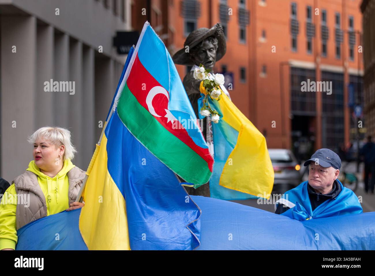 Eine Menschenmenge versammelte sich auf dem Petersplatz in Manchester mit aserbaidschanischer Flagge und ukrainischen Fahnen, um Unterstützung für die Ukraine im Krieg gegen Russland zu zeigen. Eine große Fahne wurde gehalten und kleinere Fahnen wurden über den Arm des Emmeline Pankhurst Statuts gelegt. Manchester City Centre.UK. Bild: Garyroberts/worldwidefeatures.com Stockfoto