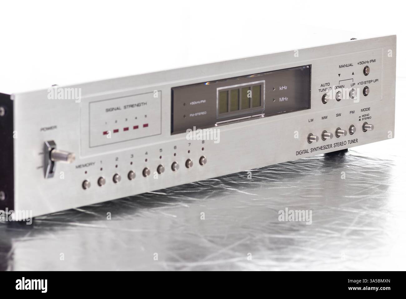 Eine Nahaufnahme eines digitalen Retro-Radio-Tuners mit Signalstärkemesser, Metallknöpfen und einem eleganten Metallic-Design. Ideal für technische Konzepte Stockfoto