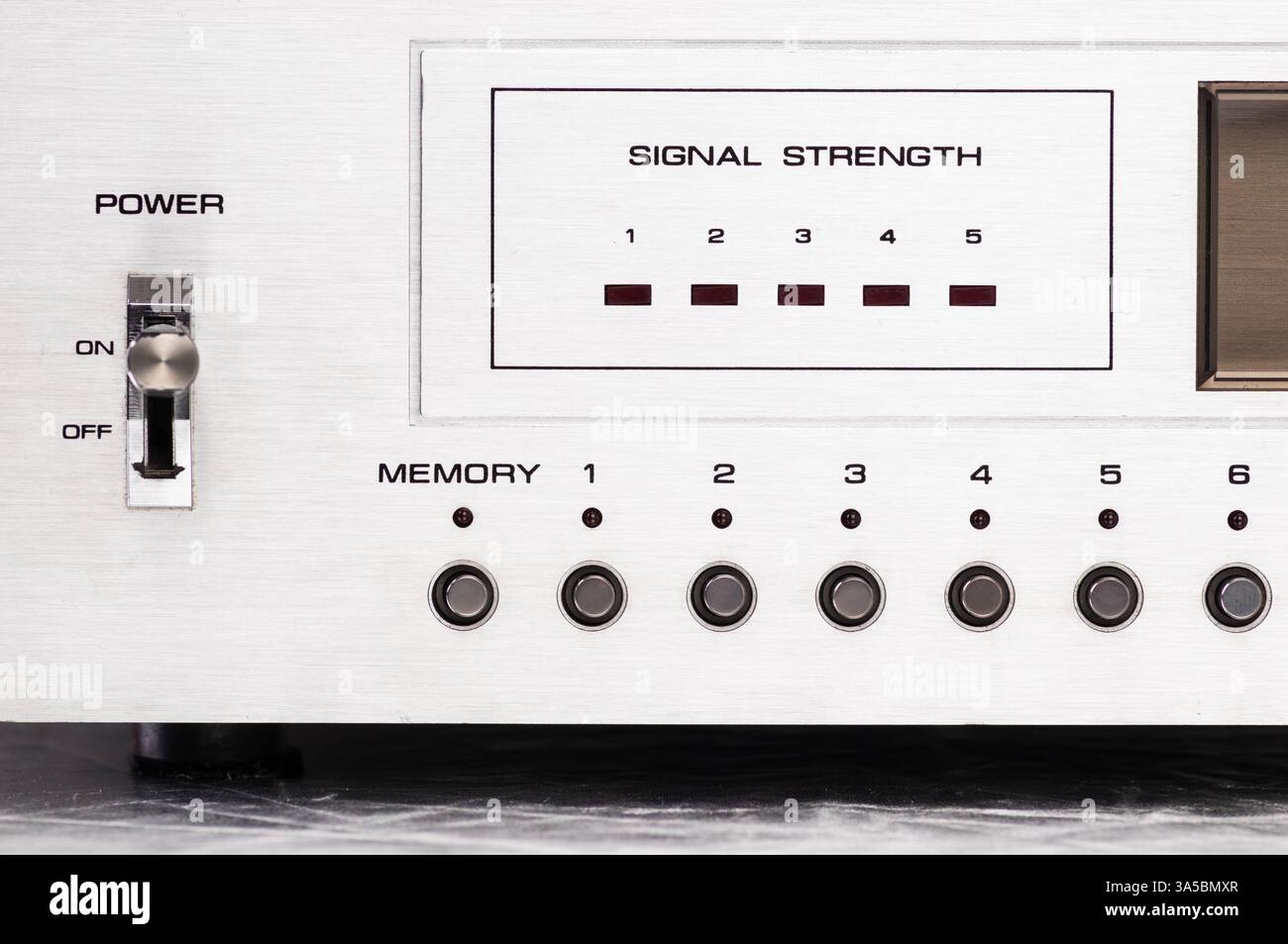 Eine Nahaufnahme eines digitalen Retro-Radio-Tuners mit Signalstärkemesser, Metallknöpfen und einem eleganten Metallic-Design. Ideal für technische Konzepte Stockfoto