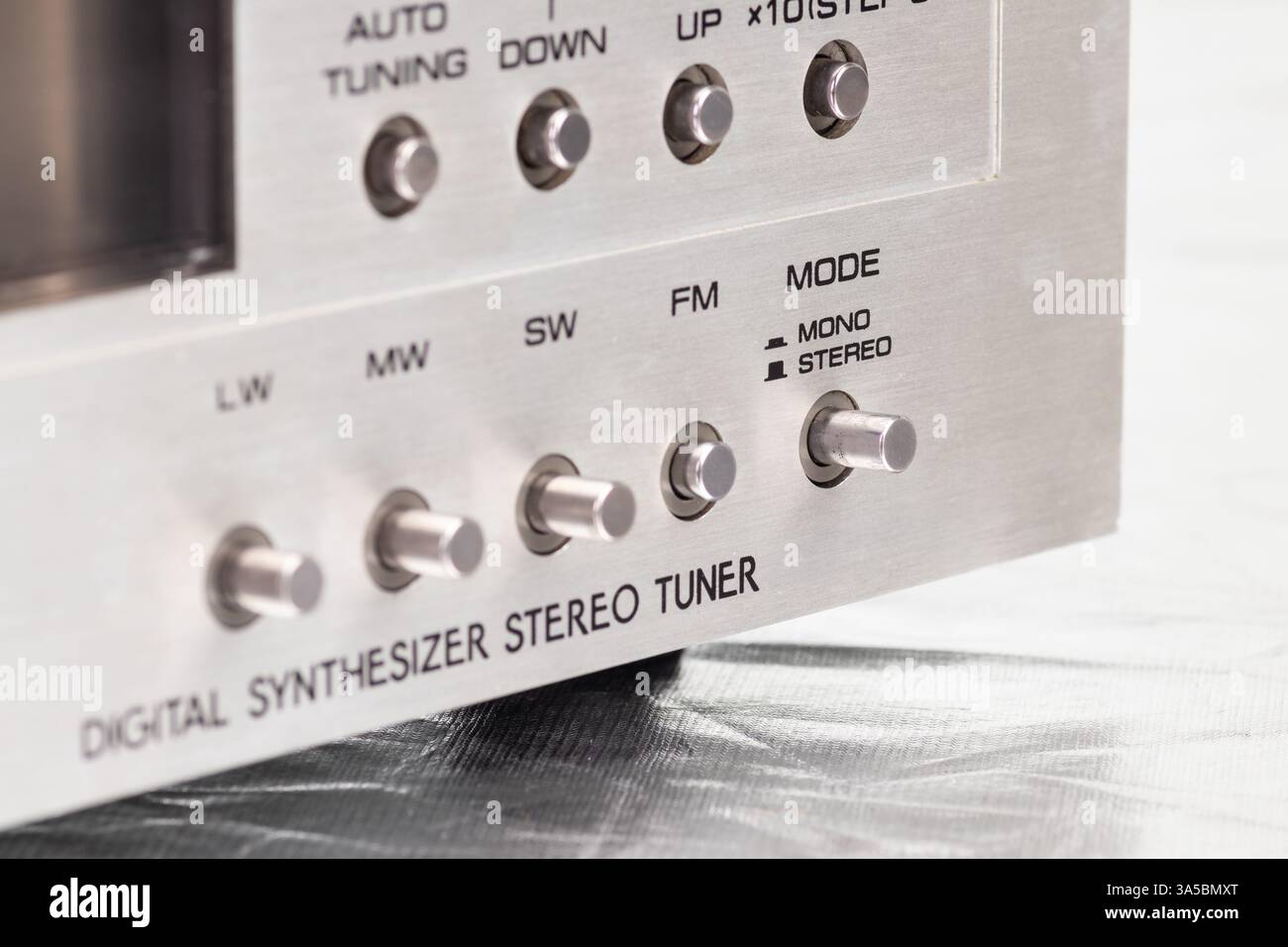 Eine Nahaufnahme eines digitalen Retro-Radio-Tuners mit Signalstärkemesser, Metallknöpfen und einem eleganten Metallic-Design. Ideal für technische Konzepte Stockfoto