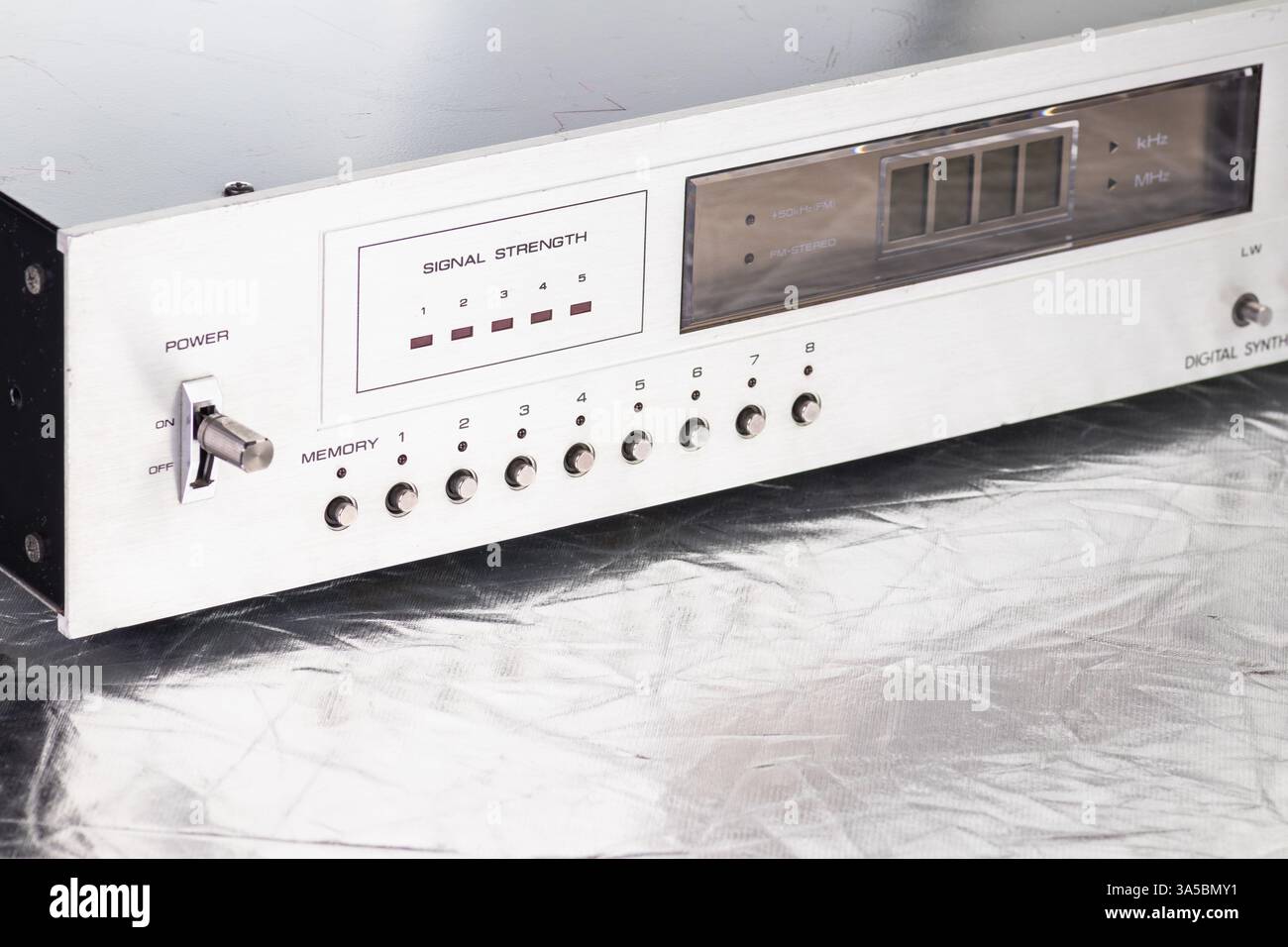 Eine Nahaufnahme eines digitalen Retro-Radio-Tuners mit Signalstärkemesser, Metallknöpfen und einem eleganten Metallic-Design. Ideal für technische Konzepte Stockfoto