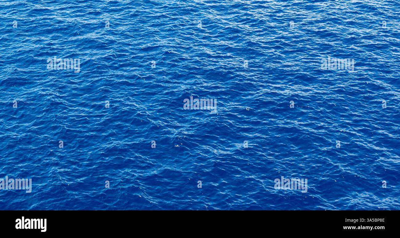 Blauer Wasserhintergrund, Meeresstruktur, Wellen auf der Oberfläche. Stockfoto