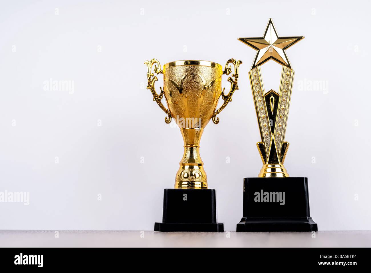 Zwei goldene Trophäen auf weißem Hintergrund Stockfoto