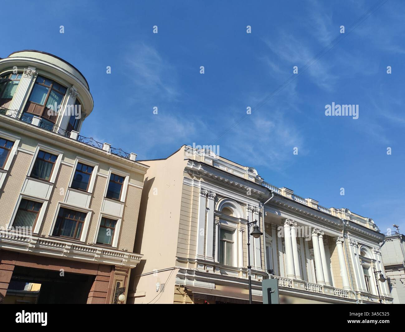 Großes mehrstöckiges Gebäude mit klassischer Fassade mit Bogenfenstern und modernen Verkaufsflächen im Erdgeschoss. Die Mischung aus traditionellem Stockfoto