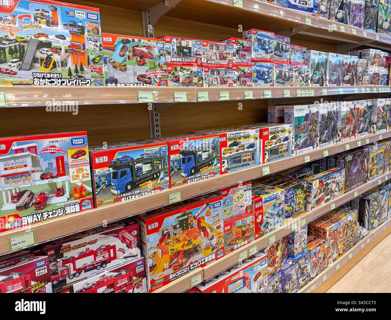 Regale mit Spielzeugautos, Spielsets und Fahrzeugen der Marke Tomica, die in einem Geschäft in Hongkong ausgestellt werden. Stockfoto