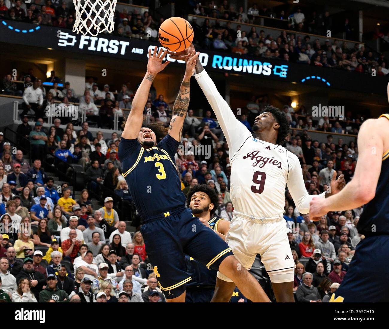 Texas A&M forward Solomon Washington, right, blocks a shot by Michigan guard Tre Donaldson during the first half in the second round of the NCAA college basketball tournament Saturday, March 22, 2025, in Denver. (AP Photo/John Leyba) Stockfoto